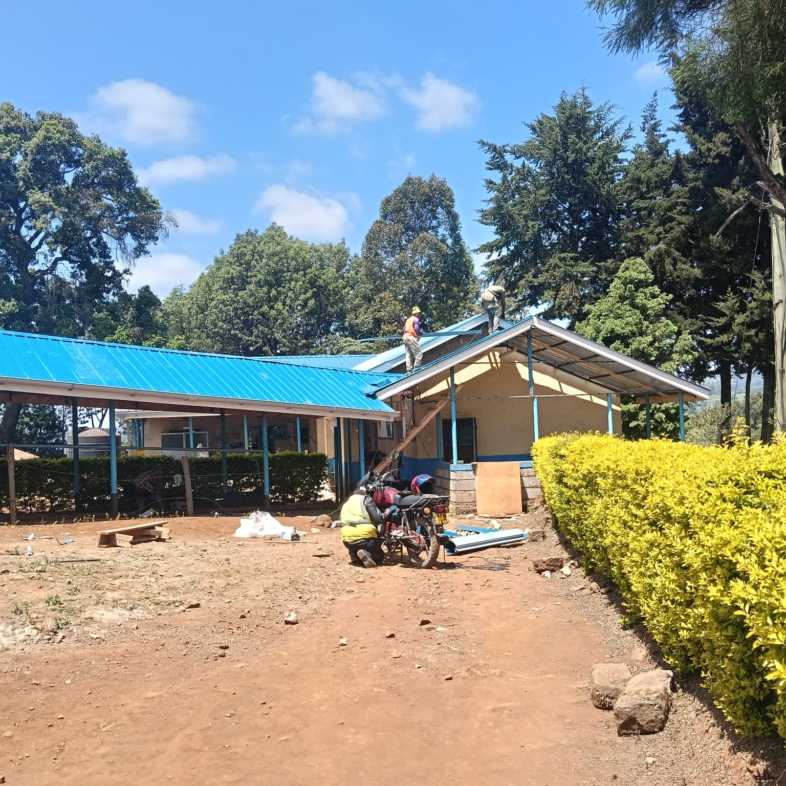Barette Construction crew fitting the new roofing sheets over the patient wing.